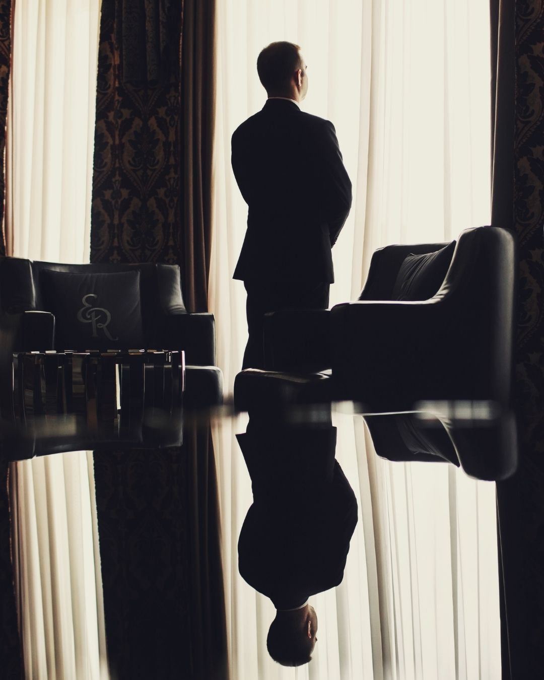 Man standing in office looking out the window